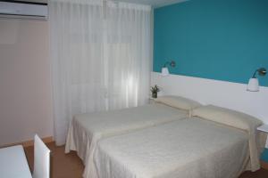 een slaapkamer met een bed en een blauwe muur bij Verona in Granada