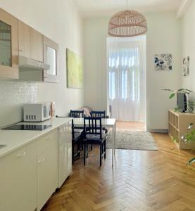 a kitchen and dining room with a table and chairs at Gallys Apartments in Prague