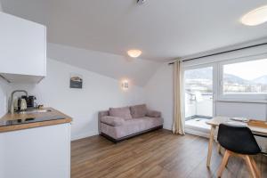 una cucina e un soggiorno con divano e tavolo di Alpen Apartment + Sauna und Netflix a Piesendorf