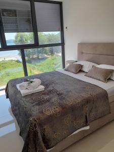 Un dormitorio con una cama grande con una ventana grande. en apartman_maree, en Herceg-Novi
