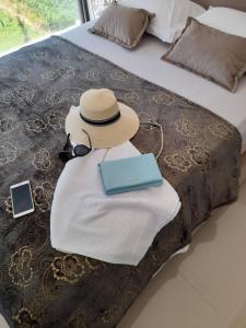 un sombrero y un libro encima de una cama en apartman_maree, en Herceg-Novi