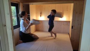 a woman and a child playing in a room at Lacustra Cabanes accessibles en canoé et Chalets tout confort in Flayat
