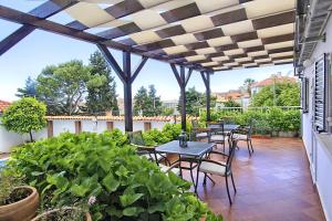 a patio with tables and chairs and plants at Villa Gloria in Dubrovnik