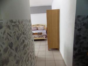 um pequeno quarto com uma cama e uma porta de madeira em Ladadika Studios em Tessalônica