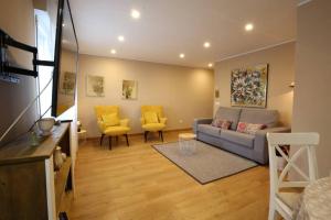 sala de estar con sofá y 2 sillas amarillas en Apartamento Oviedo Foncalada, en Oviedo