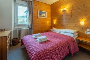 サン・ジャン・ド・シックスにあるHotel Les Aravisのベッドルーム1室(ベッド2台、ベッド上にタオル付)