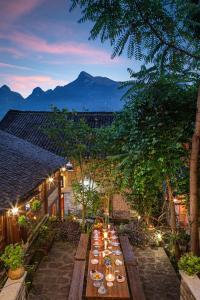 a long table in a garden with mountains in the background at Yangshuo Secret Garden in Yangshuo