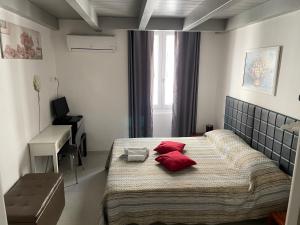1 dormitorio con 1 cama grande con almohadas rojas en Saturno house Cagliari Center, en Cagliari