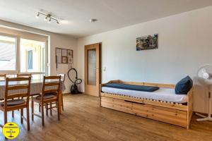 a bedroom with a bed and a table and chairs at Ferienwohnung beim Europa-Park Rust in Rust