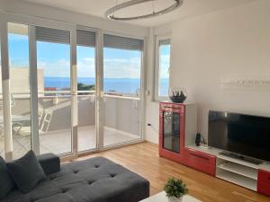 een woonkamer met een bank en een flatscreen-tv bij Apartment Vista Makarska in Makarska