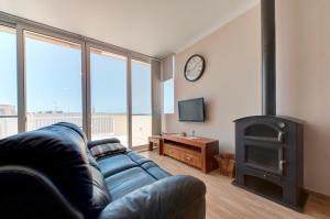 sala de estar con sofá y estufa de leña en Modern Seaside 2 BR APT w Spectacular Views en St Paul's Bay