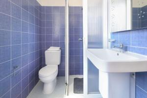 un bagno piastrellato blu con un water e un lavandino di Ta Gianni Guest House a Sliema