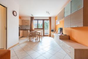 cocina y sala de estar con mesa y sillas en Appartamento Le Vele, en Riva del Garda