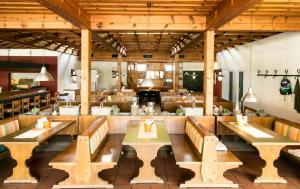 restauracja z drewnianymi stołami i ławkami w środku w obiekcie Camping Breznik w mieście Sankt Kanzian