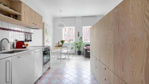 a kitchen with white cabinets and a pink tile floor at Maya's Flats & Resorts 37 - Piwna in Gdańsk