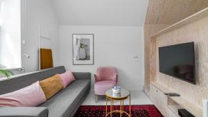 uma sala de estar com um sofá e uma televisão em Maya's Flats & Resorts 37 - Piwna em Gdansk