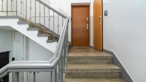 a hallway with stairs and a wooden door at Maya's Flats & Resorts 37 - Piwna in Gdańsk