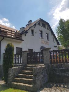 a white house with a fence and some stairs at Penzion U Elišky in Liberec