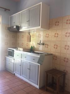 a kitchen with white cabinets and a stove at Nikolas Apartments Yianna, Kalami bay sea view in Kalami