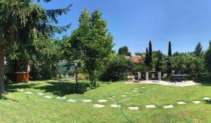 un patio de césped con un camino de piedra en el césped en VÁRLAK VENDÉGHÁZ, en Siófok