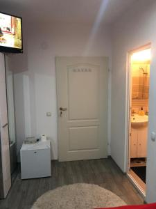 a living room with a white door and a sink at CASA BARZA in Orăştie