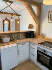 a kitchen with white cabinets and a counter top at Ferienappartement am See III in Schorfheide