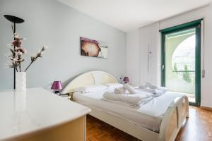 1 dormitorio blanco con 2 camas y ventana en Brione paradise, en Riva del Garda