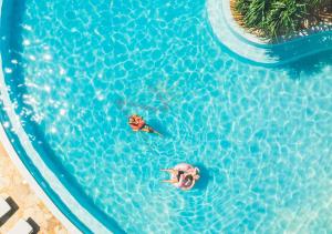 an overhead view of two people swimming in a swimming pool at Zanzibar Queen Hotel in Matemwe