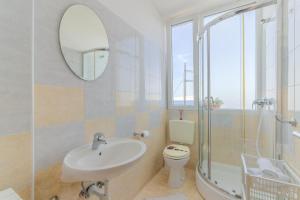La salle de bains est pourvue d'un lavabo, de toilettes et d'un miroir. dans l'établissement Ivan apartman, à Senj