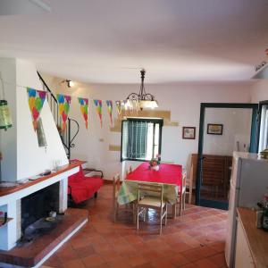 ein Wohnzimmer mit einem roten Tisch und einem Kamin in der Unterkunft Villa Tirso in Sorso