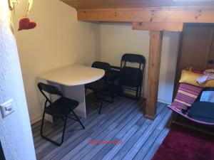 Habitación pequeña con mesa, sillas y cama en Logement chez l'habitant étage indépendant en Grône