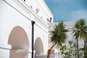 a street light next to a white building with palm trees at Masseria Donna Nina in Ostuni