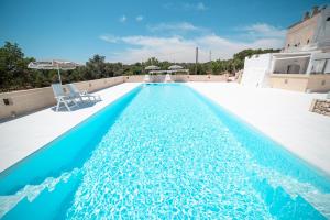 una piscina de agua azul en la parte superior de un edificio en Masseria Donna Nina, en Ostuni