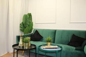 凯撒利亚Gma Caesarea的客厅配有一张绿色沙发,设有两张桌子