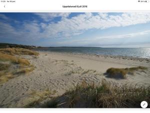 a view of a sandy beach with the ocean at Stråvalla Hulegården in Stråvalla