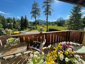 a deck with a table and chairs and flowers at Landhaus Charlotte Apartments Tirol in Seefeld in Tirol