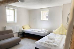 Habitación pequeña con 2 camas y sofá en Charmante Apartments mit TV-WiFi en Kelkheim (Taunus)