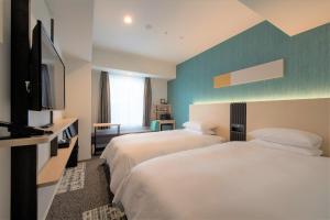 a hotel room with two beds and a flat screen tv at Tmark City Hotel Sapporo Odori in Sapporo