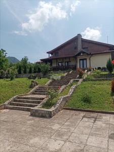 a house with a set of stairs in front of a house at Pensiunea Carma in Certeju de Sus