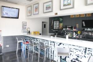 a bar in a restaurant with white stools at HOSTAL FRANCISCO SALINAS in Burgos