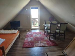 Pokój na poddaszu ze stołem i krzesłami oraz sypialnią w obiekcie Pokoje i Apartamenty u Anny w mieście Mikołajki