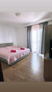 a bedroom with a bed with two red pillows on it at Blue Sky Apartments in Slatine