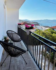 een balkon met 2 stoelen en uitzicht op de oceaan bij Blue Sky Apartments in Slatine