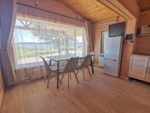 a kitchen with a table and chairs and a refrigerator at Okunevaya Holiday Park in Ozerki