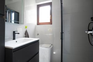 a bathroom with a sink and a toilet and a window at Apartment Juraj in Rovinj