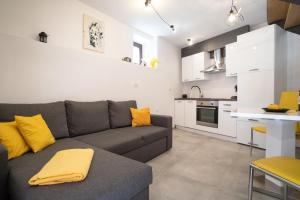 a living room with a gray couch and a kitchen at Apartment Juraj in Rovinj