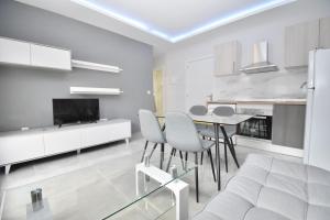 una sala de estar blanca con mesa y sillas en Luxury Suites Fuengirola en Fuengirola