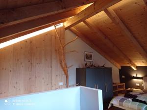 a bedroom with a wooden ceiling with a tree on the wall at Telemark Mountain Rooms in Agordo