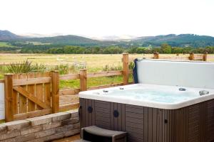 Hideaway Lodge في كينغروس: حوض استحمام ساخن على فناء مع سور وميدان