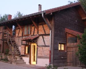 Cette cabane en rondins est dotée d'une porte en bois et d'un escalier. dans l'établissement La Poulette, à Montpont-en-Bresse